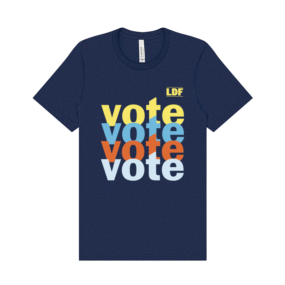 A navy blue short-sleeve t-shirt with a stacked 'vote' graphic in yellow, light blue, orange, and white on the front, plus a small yellow 'LDF' logo in the upper right of the print.