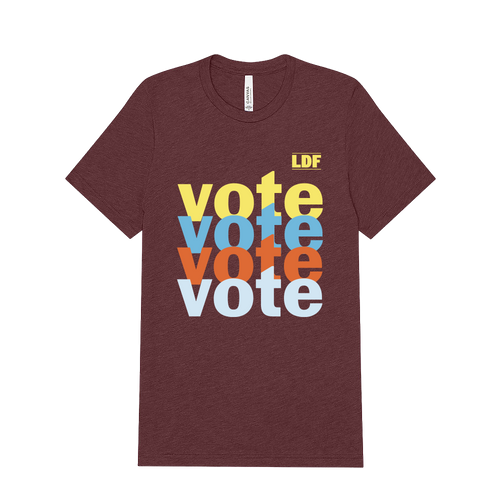 A heathered maroon short-sleeve t-shirt with a stacked 'vote' graphic in yellow, light blue, orange, and white on the front, plus a small yellow 'LDF' logo in the upper right of the print. The shirt is shown flat against a solid white background.